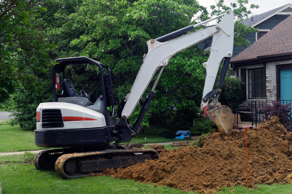 Excavator digging out lawn